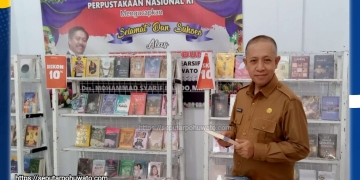 Asisten Pemerintahan dan Kesra Sekretariat Daerah Kabupaten Pohuwato Hi. Arman Mohamad, S.Pd.I., M.Si, saat berkunjung ke Perpustakaan membaca buku. (Foto: SeputarPohuwato.com)