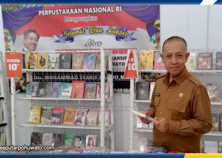 Asisten Pemerintahan dan Kesra Sekretariat Daerah Kabupaten Pohuwato Hi. Arman Mohamad, S.Pd.I., M.Si, saat berkunjung ke Perpustakaan membaca buku. (Foto: SeputarPohuwato.com)