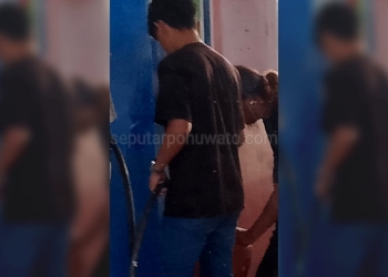 Salah seorang oknum petugas diduga sedang melayani pengisian BBM jenis pertalite di jerigen di luar jam operasional di SPBU 74.962.10 Desa Buhu Jaya, Kecamatan Paguat, Kabupaten Pohuwato