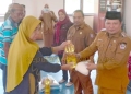 Camat Paguat Andri Pakilie, S.STP, didampingi Kepala Dinas Sosial, Pemberdayaan Perempuan, Perlindungan Anak, Pengendalian Penduduk, dan Keluarga Berencana Provinsi Gorontalo, Reflin Buata, saat menyerahkan bantuan pangan kepada 128 KPM, Selasa (07/04/2026)