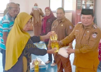 Camat Paguat Andri Pakilie, S.STP, didampingi Kepala Dinas Sosial, Pemberdayaan Perempuan, Perlindungan Anak, Pengendalian Penduduk, dan Keluarga Berencana Provinsi Gorontalo, Reflin Buata, saat menyerahkan bantuan pangan kepada 128 KPM, Selasa (07/04/2026)