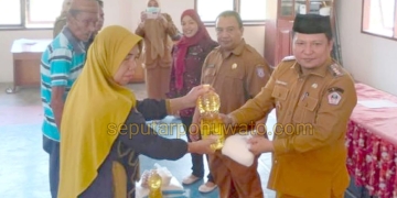 Camat Paguat Andri Pakilie, S.STP, didampingi Kepala Dinas Sosial, Pemberdayaan Perempuan, Perlindungan Anak, Pengendalian Penduduk, dan Keluarga Berencana Provinsi Gorontalo, Reflin Buata, saat menyerahkan bantuan pangan kepada 128 KPM, Selasa (07/04/2026)