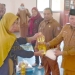 Camat Paguat Andri Pakilie, S.STP, didampingi Kepala Dinas Sosial, Pemberdayaan Perempuan, Perlindungan Anak, Pengendalian Penduduk, dan Keluarga Berencana Provinsi Gorontalo, Reflin Buata, saat menyerahkan bantuan pangan kepada 128 KPM, Selasa (07/04/2026)