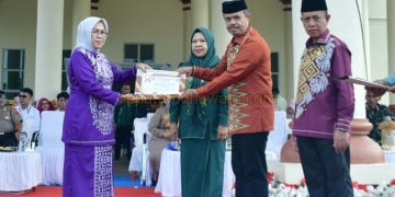 Sekda Pohuwato Iskandar Datau didampingi Kepala Disdikbud Arman Mohamad ketika menyerahkan piagam penghargaan purna bakti kepada 6 Guru pensiunan, Senin (04/05/2026).