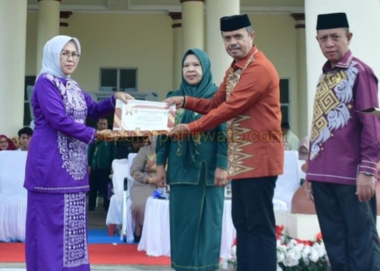 Sekda Pohuwato Iskandar Datau didampingi Kepala Disdikbud Arman Mohamad ketika menyerahkan piagam penghargaan purna bakti kepada 6 Guru pensiunan, Senin (04/05/2026).